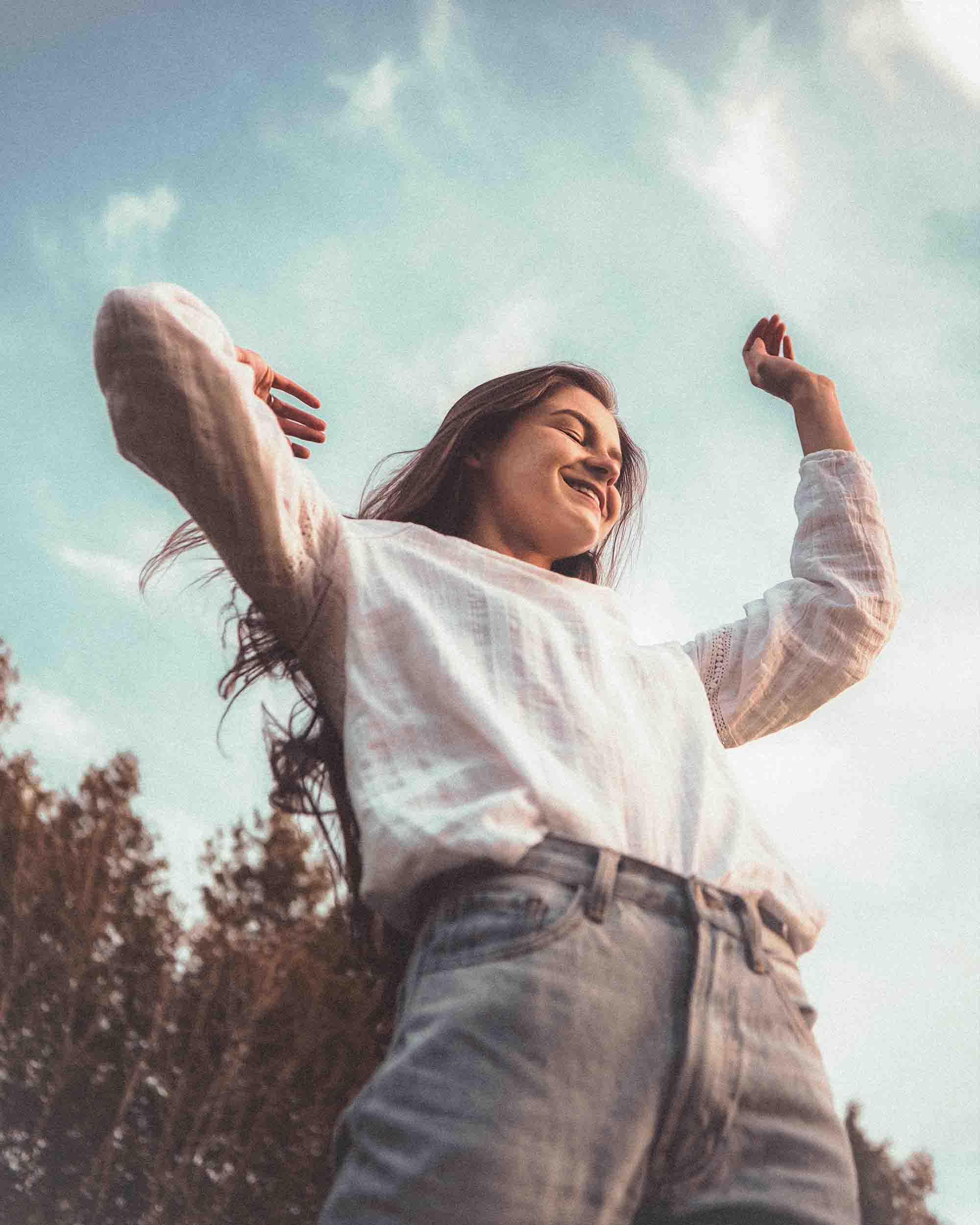young woman under overcast sunset sky